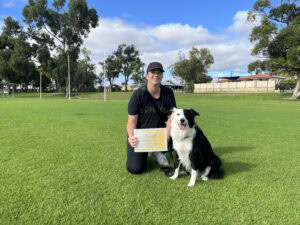 Woman with Border Collie during dog training session in park.