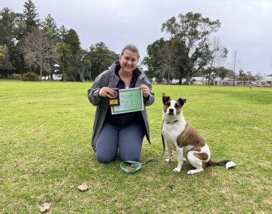 Woman with her trained dog at Agile Dogs dog training session in a park.