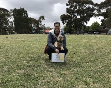 Happy woman with her dog at Agile Dogs training session outdoors.